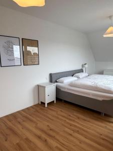 a bedroom with a large bed and a night stand at Premium Landhauswohnung in Neuenkirchen