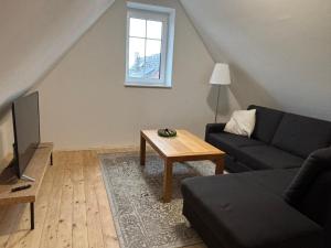 a living room with a couch and a table at Premium Landhauswohnung in Neuenkirchen