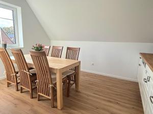 a dining room with a wooden table and chairs at Premium Landhauswohnung in Neuenkirchen +17 photos