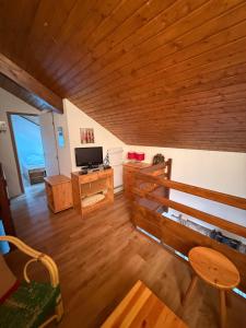 sala de estar con techo de madera y TV en beau duplex marmotiere, en Risoul