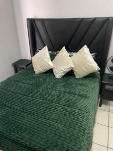 a green bed with two pillows on top of it at The Gather Inn Bethlehem in Bethlehem