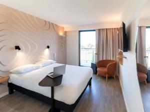 a hotel room with a bed and a chair at ibis Styles Cabriès Aix-en-Provence TGV in Cabriès