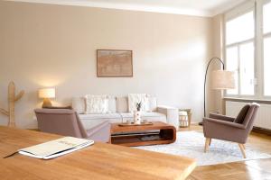 a living room with a couch and a table at Luxusapartment im Zentrum mit Schlossbergblick und Parkplatz in Graz