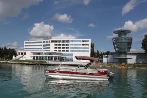 a boat in the water in front of a building at Arena Hotel Kur in Mingachevir