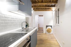 a kitchen with white walls and a wooden floor at Boutique Atrium Pantheon in Rome