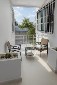 a balcony with chairs and tables on a building at Depamor in Morelia