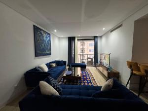 a living room with two blue couches and a table at Appartement de luxe in Sidi Daoud