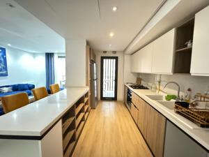 a kitchen with white countertops and wooden cabinets at Appartement de luxe in Sidi Daoud