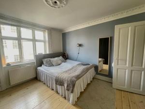 a bedroom with a bed and a large window at Apartment in heart of Amager in Copenhagen