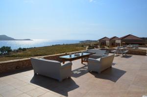 a patio with a table and chairs and the ocean at Villa Aristoteles in Halki