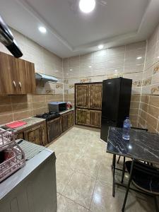 a kitchen with a black refrigerator and a table at Dar Ben Othman in Tozeur
