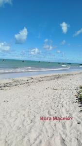 a sandy beach with the ocean in the background at A casa é Sula Hostel Maceió para mulheres in Maceió