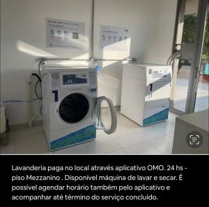 uma máquina de lavar roupa e um micro-ondas num quarto em Studio Aeroporto em São Paulo