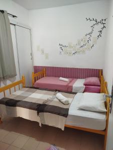 two beds sitting next to each other in a room at A casa é Sula Hostel Maceió para mulheres in Maceió