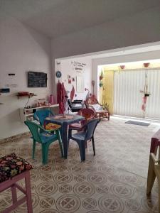 a living room with a table and chairs in it at A casa é Sula Hostel Maceió para mulheres in Maceió