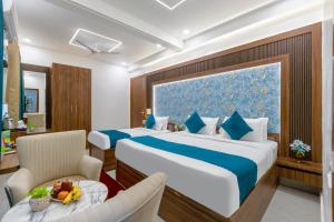 a hotel room with a large bed and a table at Honeyveils Palace Hotel - Behind Indian Expo Mart in Greater Noida +41 photos