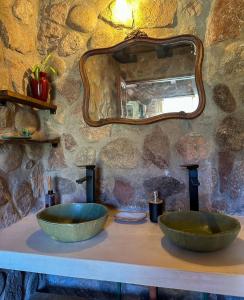 two green bowls on a counter with a mirror at Casa de piedra con jardin y pileta - privada in Los Hornillos +18 photos