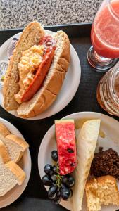 a table with plates of food with a hot dog and bread at Vila do Walbinho in Barreirinhas