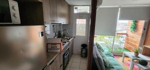 a small kitchen with a refrigerator and a window at Dep nuevo in Rancagua