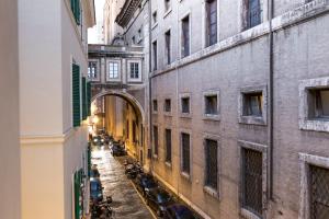 an alleyway between two tall buildings with parked cars at Boutique Atrium Pantheon in Rome