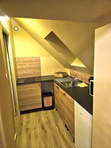 a kitchen with a sink and a counter top at Appart Cosy avec SPA privatif proximité Lille, Le Chalet in La Bassée