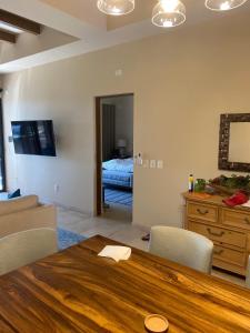 a living room with a wooden table and a bedroom at Copala At Quivira-Poolside Ground Floor Oceanview in Cabo San Lucas