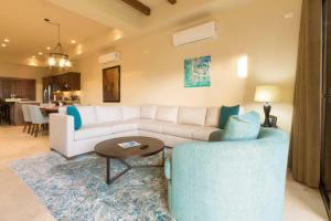 a living room with a white couch and a table at Copala At Quivira-Poolside Ground Floor Oceanview in Cabo San Lucas