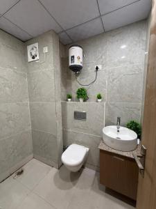 a bathroom with a toilet and a sink at Premium studios in Greater Noida