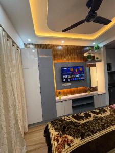 a room with a bed and a tv on a wall at Premium studios in Greater Noida