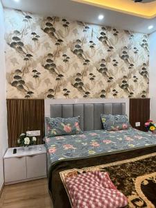 a bedroom with a bed with a floral wallpaper at Premium studios in Greater Noida