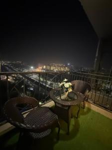 two chairs and a table on a balcony at night at Premium studios in Greater Noida