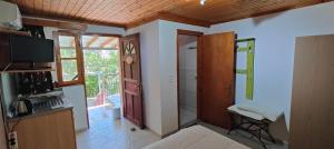 a room with a kitchen with a television and a door at Aiolis Rooms in Kamariotissa