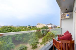 a balcony with two chairs and a large window at Honeyveils Palace Hotel - Behind Indian Expo Mart in Greater Noida