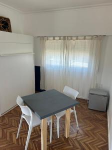 a table and two white chairs in a room at Pasala Lindo in Tandil