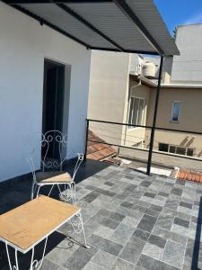 a patio with a table and chairs on a balcony at Pasala Lindo in Tandil +4 photos
