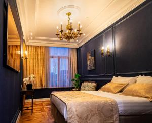 a bedroom with a large bed and a chandelier at Strands Of Time Hotel Bruges in Bruges