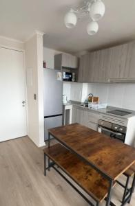a kitchen with a wooden table in a room at Departameto comodo Coquimbo HA in El Cerrillo
