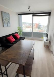 a living room with a wooden table and a couch at Departameto comodo Coquimbo HA in El Cerrillo +3 photos