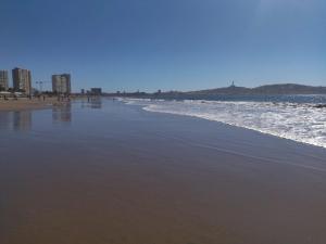 a beach with the ocean and buildings in the background at Departameto comodo Coquimbo HA in El Cerrillo