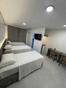 a hotel room with two beds and a television at Belaris COMFORT - NOVA UNIDADE in São Luís