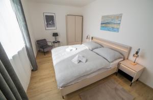 a bedroom with a bed with two towels on it at Vista Pálava - Apartmán Pasohlávky in Pasohlávky