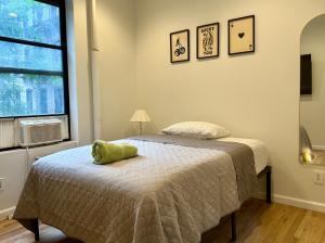 a bedroom with a bed with a green stuffed animal on it at The Marquee House in New York