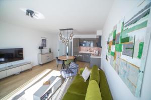 a living room with a green couch and a table at Vista Pálava - Apartmán Pasohlávky in Pasohlávky