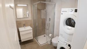 a bathroom with a shower and a washing machine at Vista Pálava - Apartmán Pasohlávky in Pasohlávky +32 photos