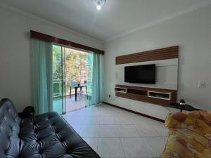 ein Wohnzimmer mit Couch und Flachbildfernseher in der Unterkunft Res. Ilha Bela in Bombinhas
