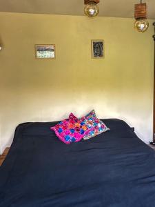 a black bed with a pillow on top of it at Casa de piedra con jardin y pileta - privada in Los Hornillos