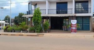 a building on the side of a street with plants at Sqore Lounge in Gulu