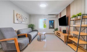 a living room with a couch and a tv at דירת הפרימיום - 5 דקות נסיעה מהים in Ashqelon +7 photos
