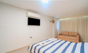 a small bedroom with a bed and a couch at דירת הפרימיום - 5 דקות נסיעה מהים in Ashqelon