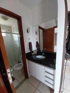 een badkamer met een wastafel, een toilet en een spiegel bij Refugio em Caldas Novas in Caldas Novas